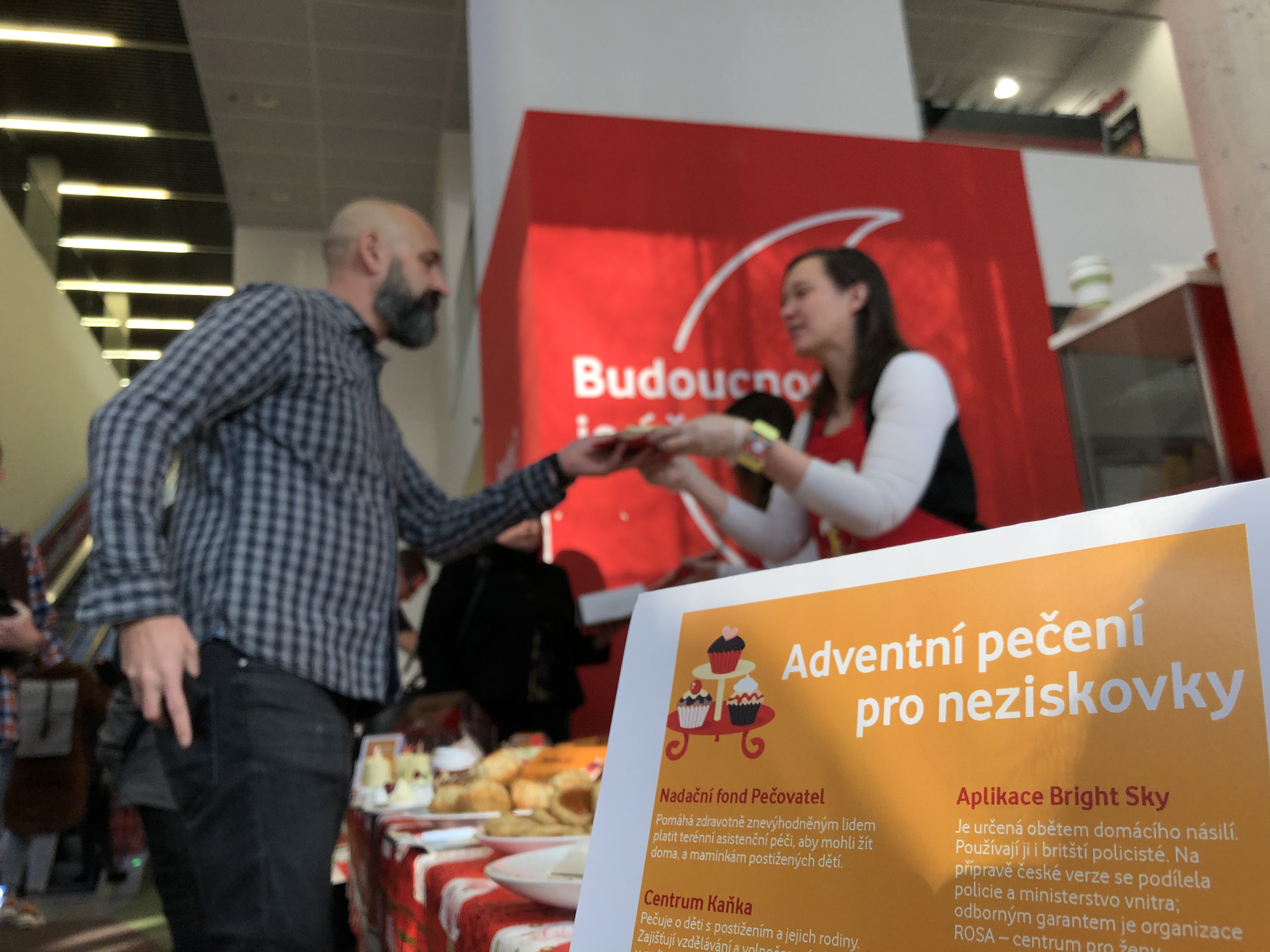 Pekařka prodává sladkost během akce Pečení pro neziskovky
